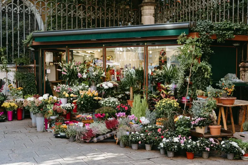 Fachada de una floristería con flores en la calle, negocio local visible en Google Maps