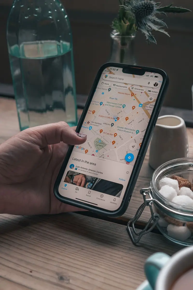 Celular con Google Maps abierto en el soporte de un auto buscando un negocio cercano