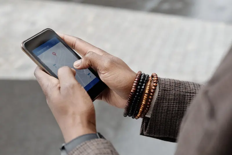 Manos sosteniendo un celular con Google Maps abierto buscando un negocio cercano