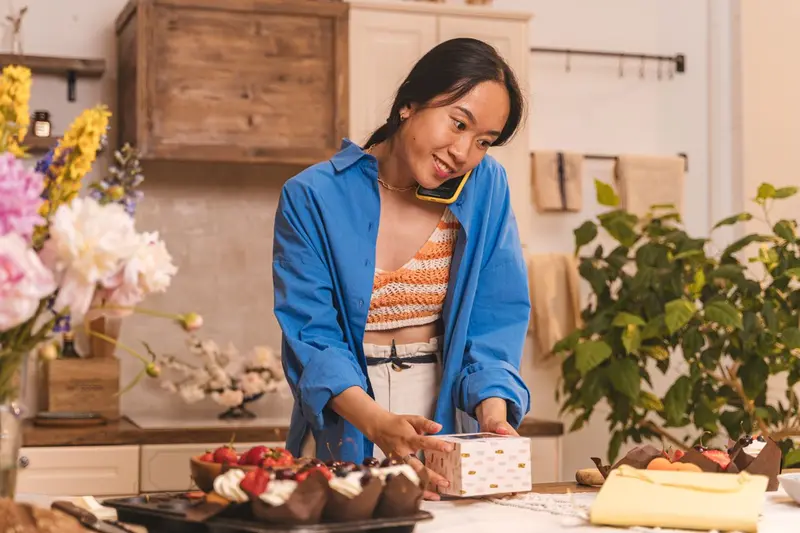 Emprendedora atendiendo un pedido por teléfono mientras prepara sus productos